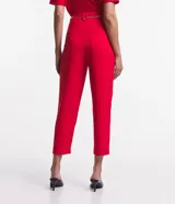 Pantalón zanahoria rojo de crepé con cintura alta, trabillas, pliegues, bolsillos y cinturón de cadena metalizada.