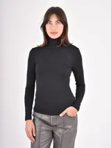 Polera de manga larga ajustada al cuerpo, con cuello alto, confeccionada en tejido suave y elástico de color negro.