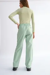 Pantalón de cuerina color marrón, de corte recto, con pretina elastizada y pasacinto.