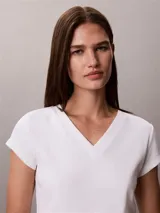 Remera de Calvin Klein Essentials confeccionada en punto de algodón elástico con textura de canalé. Presenta un diseño de corte slim, cuello en V, manga corta y una pequeña insignia con el logo de la marca en el bajo.