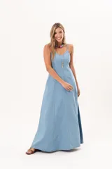 Vestido largo de denim fino y liviano, color celeste, con breteles finos, escote delicado, silueta entallada en la parte superior, falda amplia con recortes verticales y bolsillos laterales.