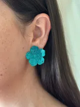 Aros con forma de flor color celeste con glitter.
