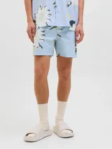 Short de baño de tiro medio con estampado floral en tonos claros sobre fondo celeste. Cuenta con cintura elástica con cordón ajustable, bolsillos laterales y un bolsillo trasero.