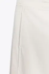 Pantalón blanco de tiro alto con pierna ancha y cordón ajustable en la cintura. Presenta bolsillos laterales y falsos bolsillos de vivo en la parte trasera.