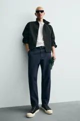 Pantalón de corte carrot fit confeccionado en tejido de algodón con estructura diagonal y efecto lavado. Presenta bolsillos frontales con bolsillo cerillero, bolsillos traseros de plastrón y cierre frontal con cremallera y botón.