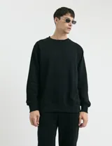 Sweater básico de cuello redondo y manga larga, confeccionado en tejido circular con puños y cuello en tejido canalé.