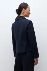 Blazer de corte recto y diseño cropped, con doble botonadura frontal, solapas clásicas y estampado de rayas diplomáticas.