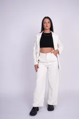 Pantalón de vestir beige con pinzas, tiro alto y perneras amplias de corte recto.