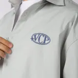 Camisa de manga corta color marfil, corte boxy, con cuello camisero, cierre frontal de botones y pequeño bordado marrón en el pecho con las siglas VCP.