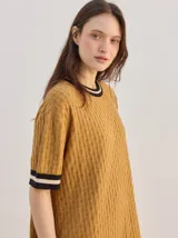 Vestido corto de algodón con estampa geométrica en tonos verde y amarillo, cuello redondo y mangas cortas con puños en color contrastante.