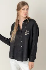 Camisa de lino color gris claro con bordado de monograma PEC en el bolsillo.