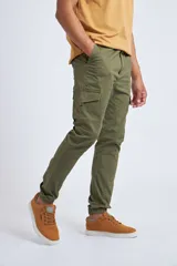 Pantalón cargo color beige con ajuste slim, cierre frontal con botón, bolsillos laterales tipo cargo y puños elásticos en los tobillos.