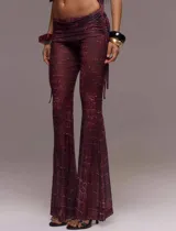 Conjunto de dos piezas compuesto por un top de manga corta con recortes, detalle metálico frontal y cuello tipo mao, y un pantalón de tiro bajo con corte flare. Ambas prendas presentan un estampado efecto piel de cocodrilo en tonos vino.