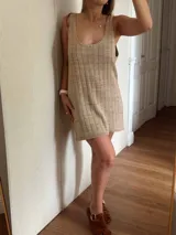 Vestido corto de tejido de punto, color marrón con hilos dorados (lurex) que le dan un brillo sutil. Diseño de tirantes anchos y escote redondo.