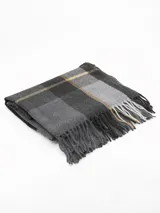 Bufanda tipo pashmina de tejido suave, color gris con diseño de cuadros en tonos oscuros y líneas finas en rosa. Presenta terminaciones con flecos en los extremos.