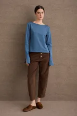 Remera de manga larga en color azul, con cuello bote y diseño ajustado al cuerpo. Presenta un acabado de borde sin costuras en el cuello y puños con abertura lateral.