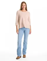 Buzo de tejido soft color beige con textura jaspeada, cuello redondo, mangas tres cuartos con detalle de botones en los puños y tajos laterales en el ruedo.