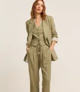 Pantalón celeste de corte recto, confeccionado en tejido de lino y viscosa. Presenta cintura elástica con lazo ajustable, bolsillos laterales y pliegues frontales.