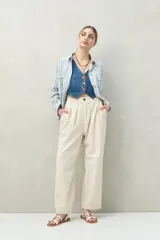 Pantalón color crema de corte ancho, con cintura alta y pinzas delanteras.