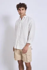 Camisa de corte regular con diseño de rayas verticales finas en tonos claros, cuello clásico y mangas largas con puños abotonados.