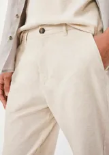 Pantalón chino de corte recto, color beige, con cierre frontal de botón y cremallera, y bolsillos laterales.