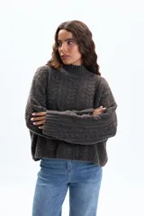 Polera de punto con diseño de textura fantasía, corte crop y cuello alto. Presenta mangas largas con puños acanalados y un calce holgado.