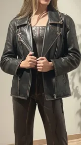 Chaqueta de cuero negra con detalles de tachas en los hombros y espalda.