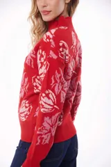 Sweater rojo con estampado de flores rosas y cuello alto.