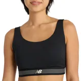 Top deportivo New Balance Train Bra, color negro con banda elástica inferior rayada en blanco y logo de la marca en el centro.