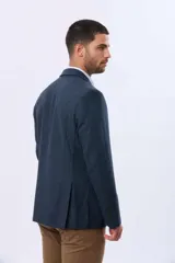 Saco sport de lana en color gris oscuro, con diseño clásico de solapa tradicional, cierre frontal de dos botones y bolsillos laterales con solapa.