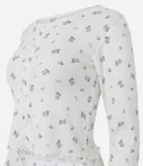 Pijama de dos piezas confeccionado en tejido de punto con estampado floral. Incluye una blusa de cuello redondo, manga larga y botones frontales, junto con un pantalón de cintura elástica.