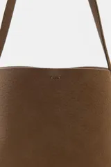 Bolso de hombro tipo saca, de diseño minimalista y estructura flexible. Cuenta con asa de hombro, cierre mediante clip metálico y compartimento interior extraíble con cremallera.