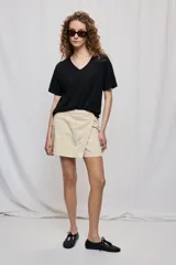 Short cruzado de tiro medio con diseño frontal tipo falda, color negro, de líneas simples y calce cómodo.