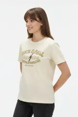 Remera de algodón negra de manga corta y cuello redondo, con estampa frontal que incluye letras rojas y gráficos en tonos dorados.