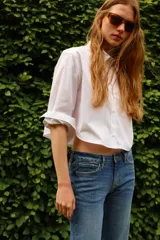 Jean de denim azul con corte slim regular, tiro medio, cinco bolsillos y cierre con cremallera y botón.