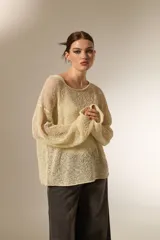 Sweater de tejido de punto calado con lurex, cuello redondo a la base y mangas largas con diseño holgado.