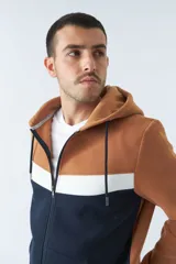 Campera negra y gris con capucha, cierre frontal y bolsillos tipo canguro.