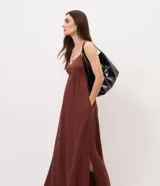 Vestido midi evasê marrón con breteles finos, escote corazón y corte en la cintura. Presenta silueta fluida con caída amplia y bolsillos laterales.