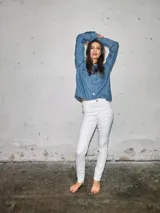 Jean skinny de tiro alto con diseño ajustado, bolsillos clásicos y cierre frontal de botón y cremallera.