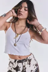 Musculosa corta de morley en color blanco, con tirantes finos y terminación con volados en el ruedo.