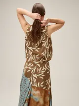 Top negro sin mangas con estampado geométrico y manchas texturizadas en tonos marrones y beige, con silueta balloon.