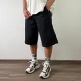 Bermuda de jean negra de corte baggy y estilo holgado, con bolsillos laterales y traseros.