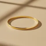 Esclava rígida tipo bombé de diseño minimalista, fabricada en oro 18k con acabado pulido brillante.