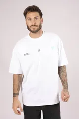 Remera blanca de algodón con cuello redondo, corte holgado y estampado pequeño en el frente.