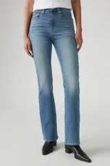 Jean azul de tiro alto, corte bootcut, con lavado medio y efecto desgastado en los muslos.