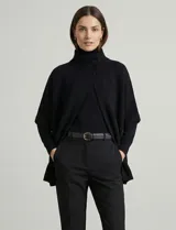 Capa tejida color fucsia, con cuello alto abotonado y mangas cortas estilo japonesa. Tejido de punto grueso.