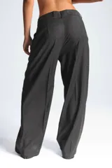 Pantalón de vestir gris oscuro, de corte palazzo, con pinzas en la cintura y bolsillos laterales.