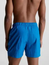 Bañador corto de largo medio Calvin Klein CK Nylon, color azul eléctrico, con cintura elástica, cordón de ajuste y cinturón de cinta con hebilla y logo. Incluye bolsillos laterales, bolsillo trasero con cremallera y forro de malla.