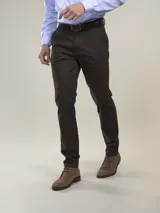 Pantalón de vestir azul marino, de corte recto, con bolsillos laterales y traseros. Se ajusta a la cintura con cinturón de cuero marrón.