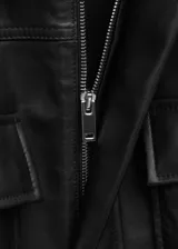 Parka oversize de piel ovino en color negro, con cuello de solapa, manga larga, bolsillos delanteros con solapa y cintura ajustable.